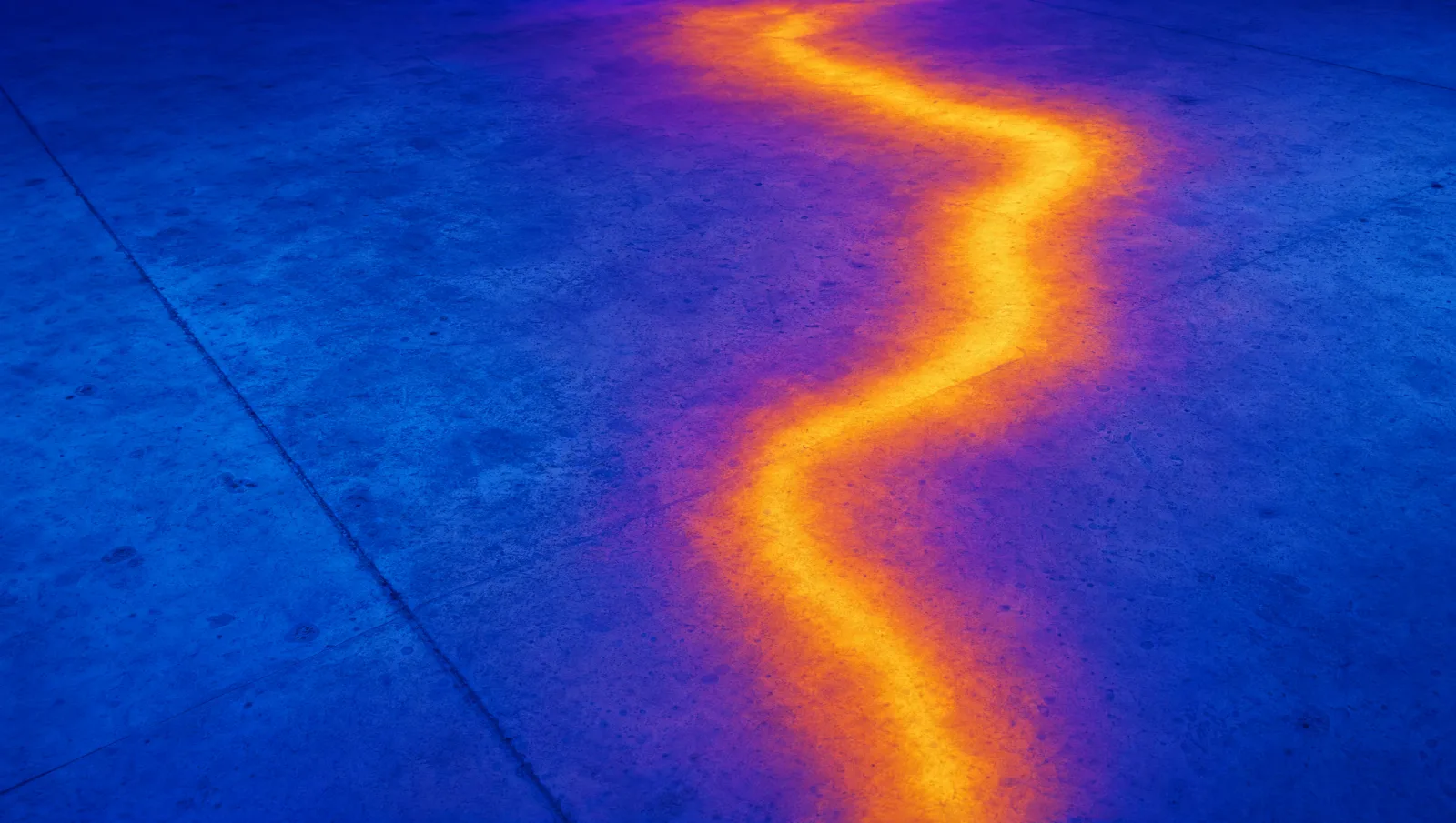Thermal image of a concrete floor slab showing a warm plume tracing the path of a buried hot water line.